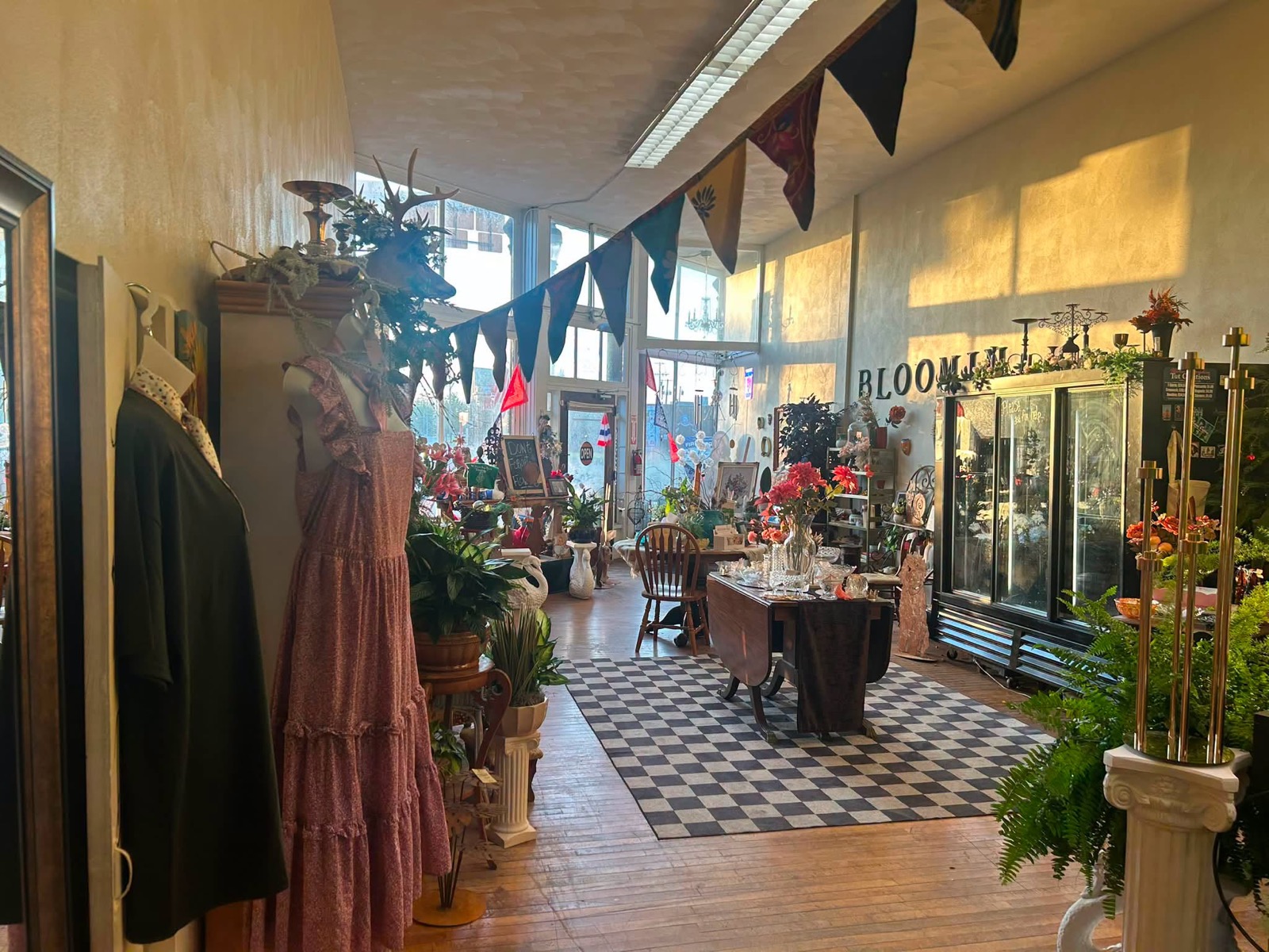 Inside Bloomin On Broadway — a bright, eclectic shop with flowers, plants, vintage furniture and a boutique clothing rack